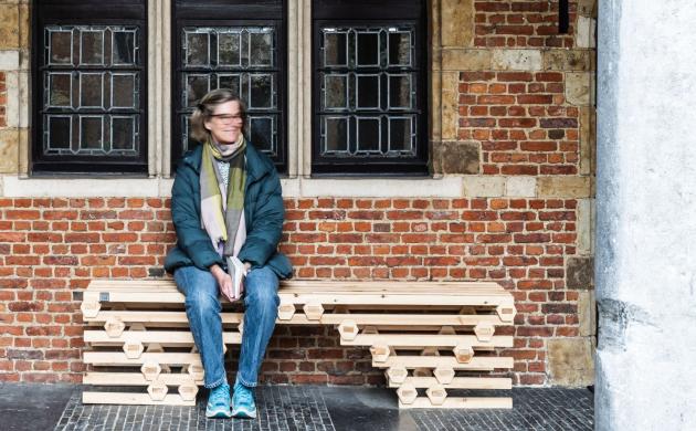 vrouw zit op een bankje, gemaakt door architectuurstudent, in de binnentuin van het museum 