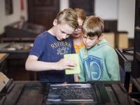 kinderen aan de drukpers tijdens een workshop